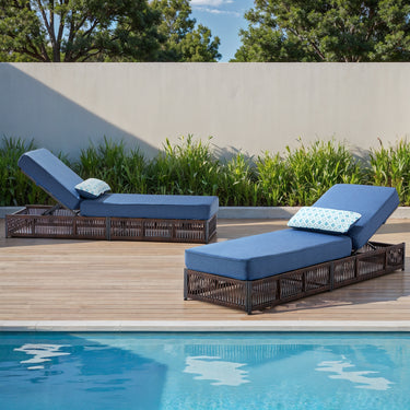 Set of 2 Belord luxury patio chaise lounges with brown wicker frames and blue cushions, featuring reclining backs for poolside relaxation.