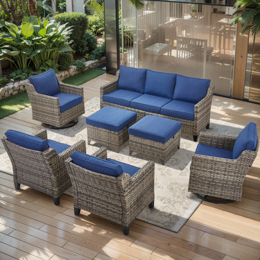Belord 7-piece patio conversation set with wicker sofa, swivel chairs, and ottomans, shown in an outdoor garden setting.