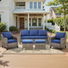 Belord 6-piece wicker patio conversation set with sofa, two chairs, two ottomans, and side table for outdoor lounging.
