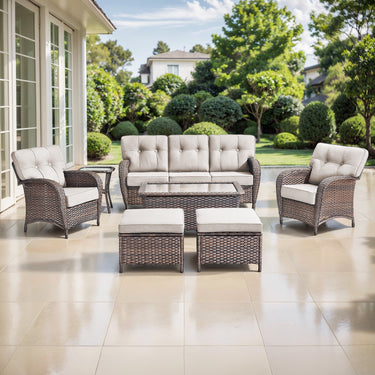Belord 7-piece patio conversation set with brown wicker, beige cushions, includes sofa, chairs, tables, and footstools.