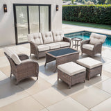 Belord 7-piece patio conversation set with brown wicker, beige cushions, including sofa, chairs, tables, and footstools.