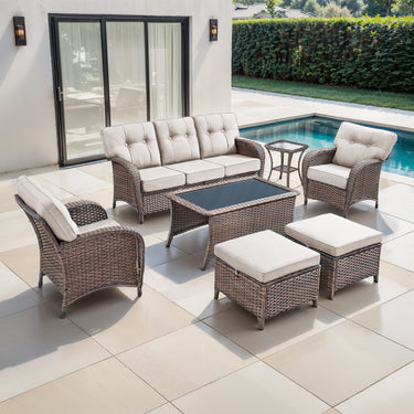 Belord 7-piece patio conversation set with brown wicker, beige cushions, including sofa, chairs, tables, and footstools.