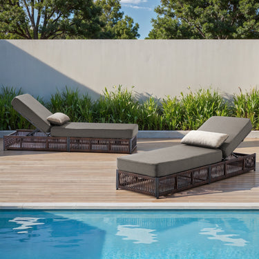 Set of two Belord luxury chaise lounges with brown wicker frames and grey cushions, featuring reclining backs for poolside relaxation.